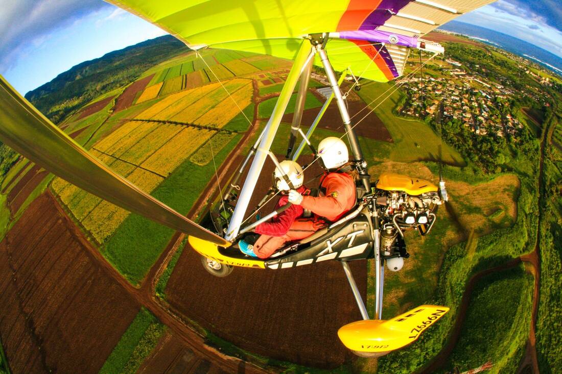 The trike over green fields, hills and a town in the distance