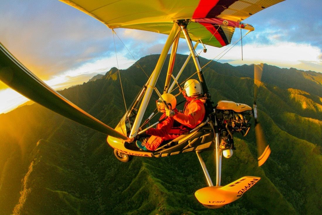 Flying toward green mountain ridges in low golden light